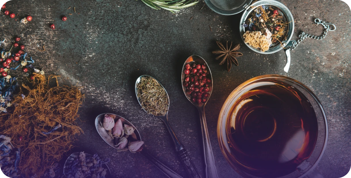 Assorted spices and tea on dark surface